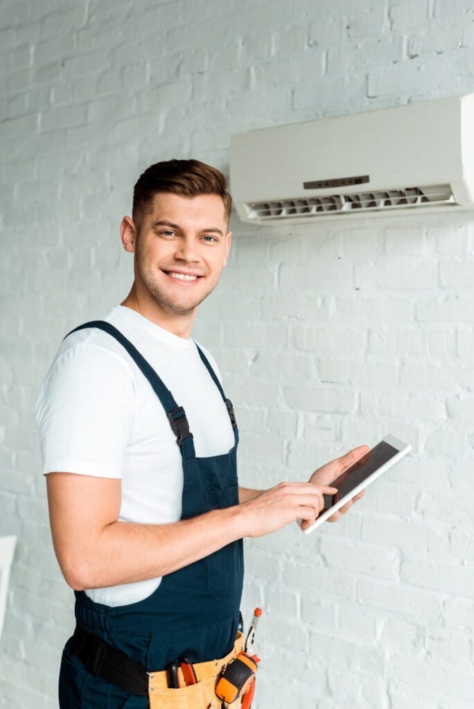 Installateur présentant un devis sur tablette près d'un climatiseur