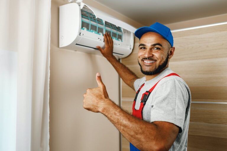 Technicien installant une unité intérieure de climatisation murale